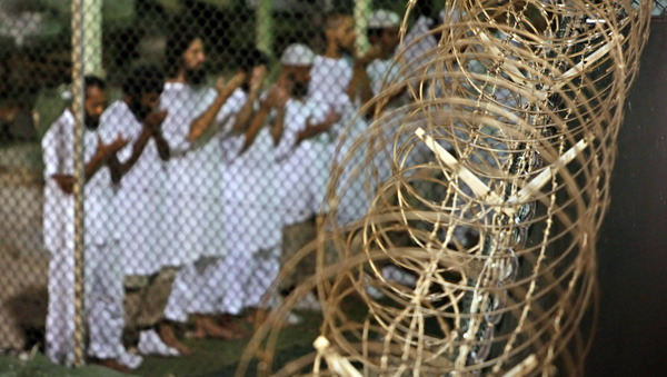 In this May 14, 2009, file photo, reviewed by the US military, Guantanamo detainees pray before dawn near a fence of razor wire, inside Camp 4 detention facility at Guantanamo Bay US Naval Base, Cuba (AP photo)